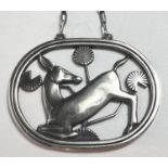 Georg Jensen: an oval openwork silver pendant with deer kneeling amongst foliage, stamped GJ, 9255