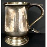 A hallmarked silver baluster pint mug, monogrammed, with 'S' scroll handle, on circular foot, London