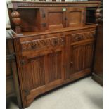 A reproduction carved oak court cupboard with double cupboard over 2 cupboards and 2 drawers