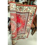 A 20th century Persian rug with red ground