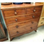 A mahogany chest of three long two short drawers with ogee feet bun handles and wooden escutcheons