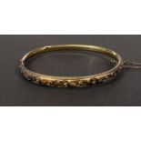 A 15 carat hallmarked gold rigid hinged bangle with filigree decoration, 6.75gm (2 dents)