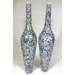 A Chinese pair of vases, tall and thin with thin neck and foot with scrawling blue and white