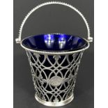 A mid Georgian silver sugar basket with swing handle and blue glass liner, London 1770, maker Thomas