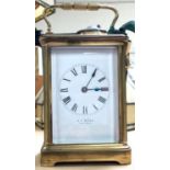 A late 19th/early 20th century brass carriage clock with bevelled glass, white enamel dial by R.