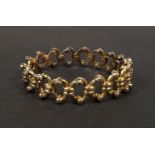 A yellow metal bangle with expanding concertina action, stamped '15', 15.5gm