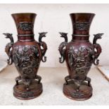 A late 19th century pair of Japanese bronze baluster vases, 2 handled in the form of griffins,
