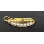 A Chinese/Japanese yellow metal brooch in the form of a split pod of peas formed from pearls, with