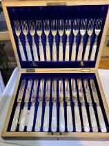 A cased set of 12 mother of pearl and etched silver plated knives and forks with hallmarked silver