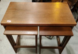 A set of teak mid century tables with fold out top and two tables below and a vintage salter trolley