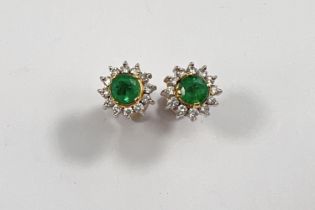 A pair of 18ct white and yellow gold earrings set with central emerald approx 4mm surrounded by