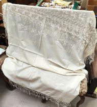 A cream  embroidered shawl with plaited fringing.