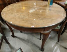A large 19th century Georgian style oak circular dining table on four cabriole legs with ball and