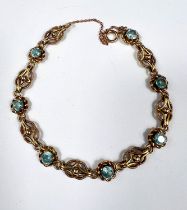A Victorian yellow metal bracelet set alternating blue topaz and filigree links, unmarked, tests