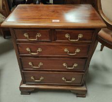 A mahogany reproduction dwarf chest of 3 long and 2 short drawers; a similar 2 height bookcase