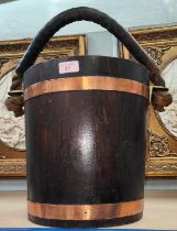 An oak bucket with copper bands, leather covered rope handle with brass mounts