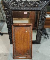 A large oak carved cushion framed, bevelled edge mirror with scrolling pierced frame and with