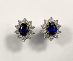 A pair of 18ct white gold earrings set with large central sapphire. Oval cut, length 7mm