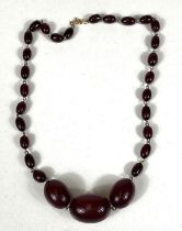 A cherry bakelite amber necklace, graduating with internal swirls, largest 2.7cm approx. clasp