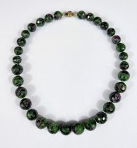 A graduating multi facetted green and purple hardstone bead necklace