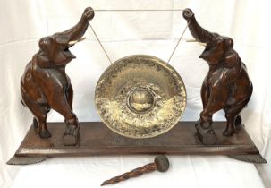A late 19th century/early 20th century Asian carved wooden gong with 2 elephants carved on plinth,
