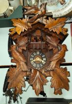 An early to mid 20th century Bavarian cuckoo clock with dancing and spinning figures and carved case