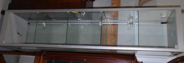 A modern satin metal and glass 5 height free standing display cabinet with lighting to each shelf