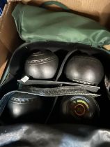 A pair of crown green bowls in bag; a set of 4 lawn bowls in bag