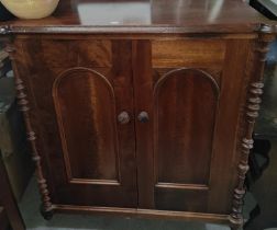 A 19th century mahogany side cabinet with 2 arched doors and turned corner columns