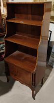 A crossbanded mahogany waterfall bookcase, 3 height with cupboard under