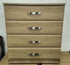 A modern light oak effect 4 height chest of drawers.