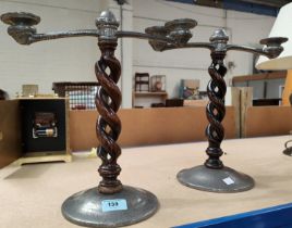 A pair of Tudric planished pewter 2 branch candelabra on open barley twist columns.