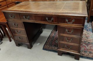 A reproduction mahogany kneehole desk with inset leather top and 9 drawers