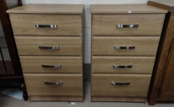 A pair of modern light oak effect 4 height chests of drawers.