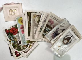 A selection of vintage postcards, many embossed with flowers