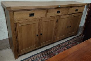 A large modern light oak side cabinet with three frieze drawers and 2 double cupboards, length