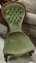 A Victorian walnut nursing chair with spoon back, in buttoned green dralon