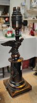 A bronzed table lamp in the form of eagle perched on column with squared base, height 29cm