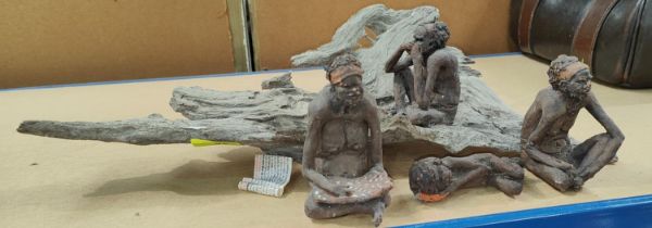 Three collages of terracotta ethnic figures on root carved stands