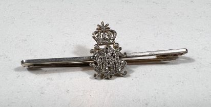 A yellow metal pin with diamond set monogram and crown, (tests 18ct), pin base metal