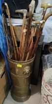 A brass stick stand; a collection of sticks