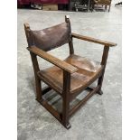 An early 20th century Arts and Crafts oak armchair in the manner of Gustav Stickley, with leather