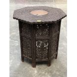 An Indian carved hardwood and brass inlaid centre table, the folding base pierced with foliage.