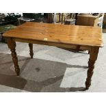 A pine kitchen table on turned legs. 53' long