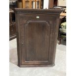 A 19th century oak hanging corner cupboard, the interior with three drawers