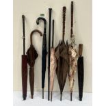 Seven vintage parasols or umbrellas and a walking cane with silver pommel