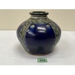 A Royal Doulton Lambeth vase, decorated with bands of leafy foliage on a blue ground. Signed HB to