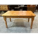 A modern pine kitchen table with frieze drawer on turned legs. 59' long