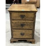 An oak bedside chest of three drawers on bracket feet