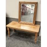 A pine low table on turned legs, 44' long and a pine framed mirror with bevelled plate